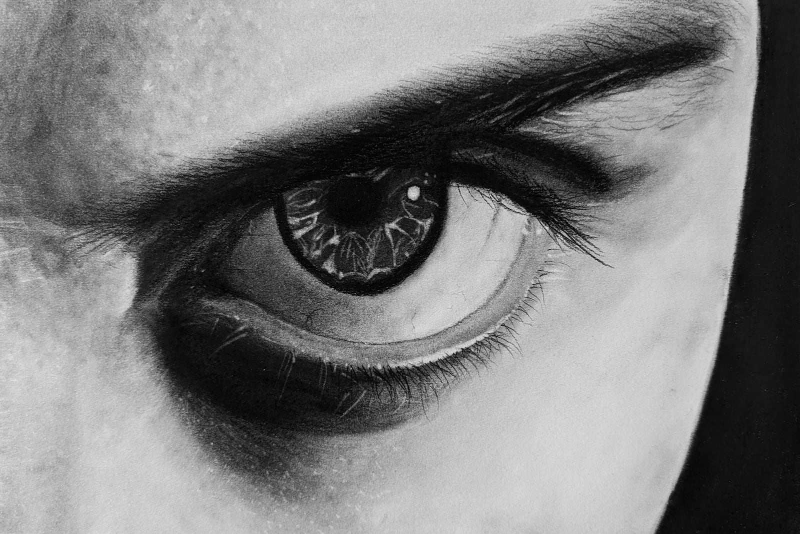 Charcoal drawing of a single eye under a heavy brow, gazing sideways, in close-up